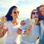 Women eating ice cream enjoying their summer vacation and feeling confident in their bodies