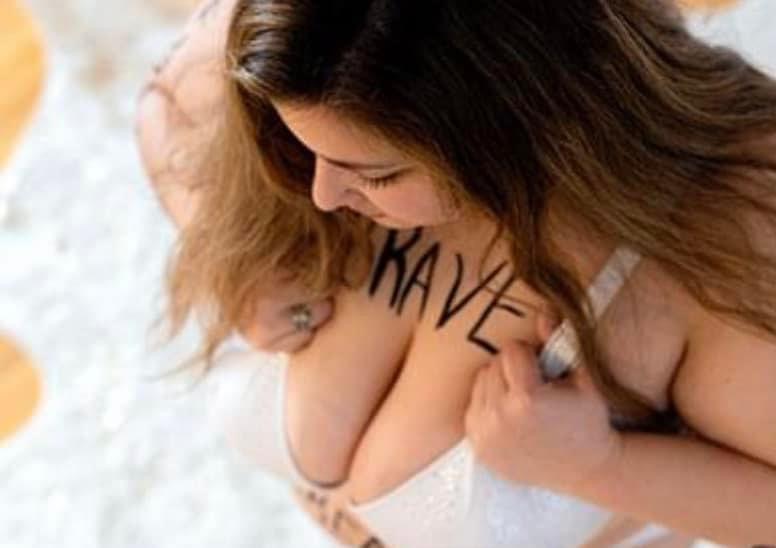 Girl with long brown hair wearing a white bra with the word Brave written on her chest for her In The Rawboudoir session.